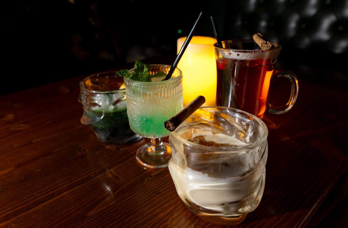 Specialty cocktails including the butterbeer, forefront, at Speakeasy 9¾ inside The Twisted Pig Bar and Grill in Modesto on  Wednesday, Dec. 10, 2025.