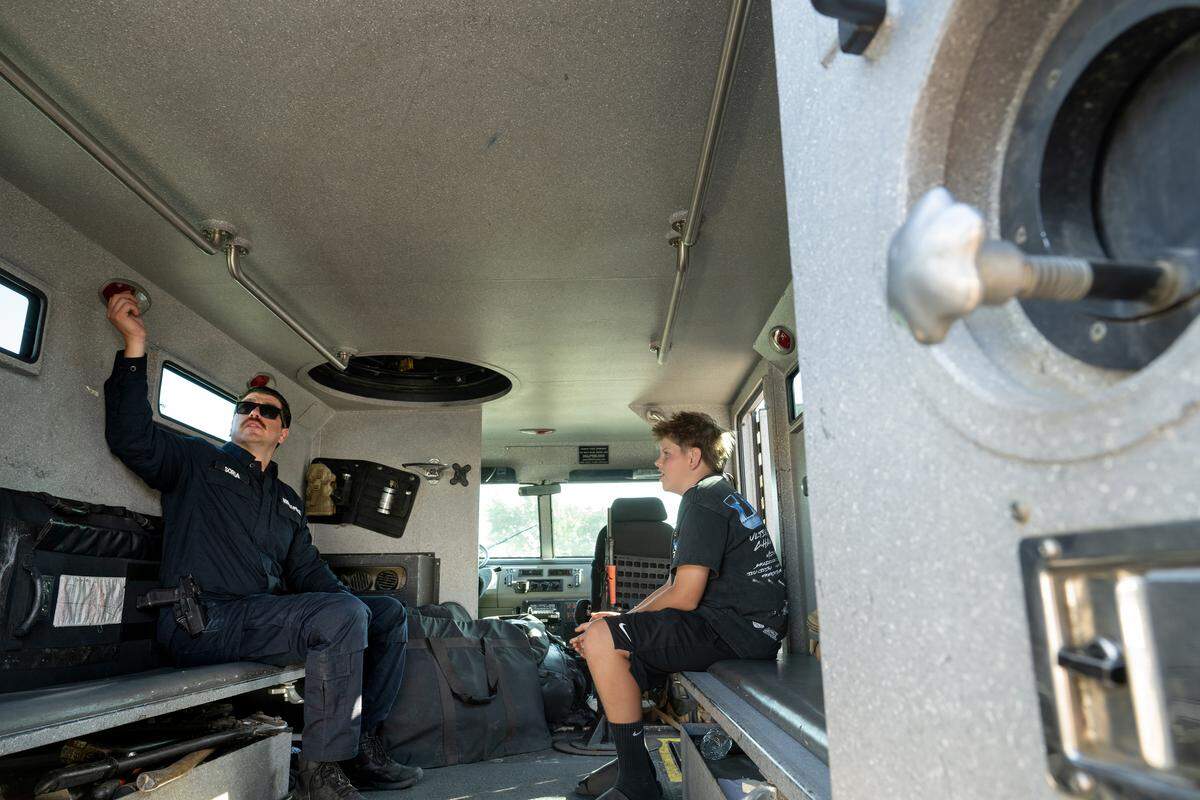 MPD Officer Brandon Soria shows Ryder Mejorado the inside of an armored personnel carrier during an open house event at the Modesto Police Department on Tuesday, May 19, 2026. 
