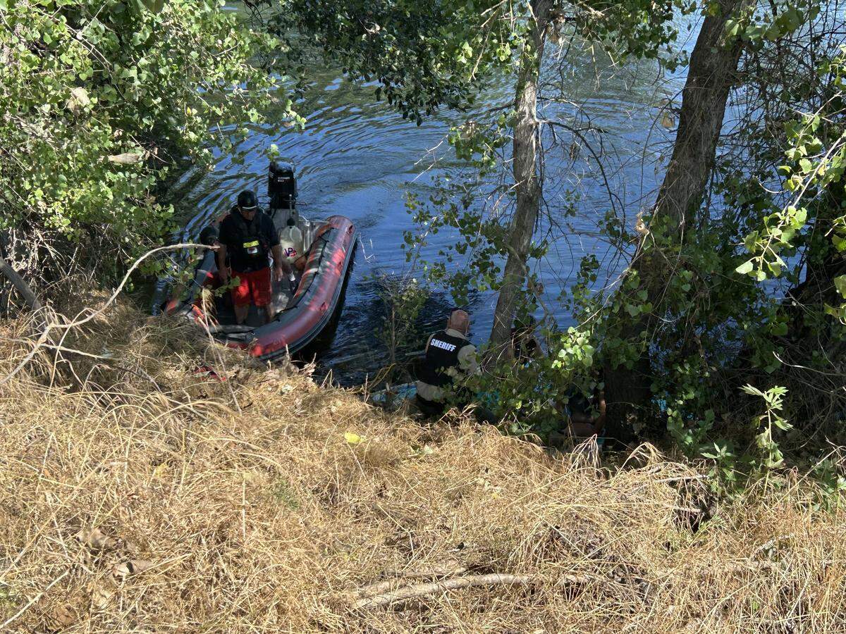 A rescue boat approaches brush along the Stanislaus River where stranded rivergoers were located during a Memorial Day weekend rescue in Oakdale.