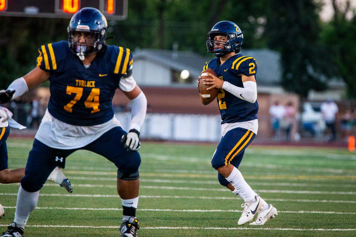 Turlock High quarterback Vincent Gonzales (2) gets protection from offensive lineman Nelson Lozano (74) as he looks up field for an open receiver during Friday night’s game at Joe Debely Stadium.