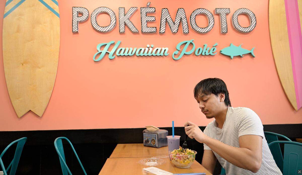 Jermel Cosido eats a poke bowl at the new Pokémoto Hawaiian Poké restaurant in Village One Plaza in Modesto, Friday, March 28, 2025.