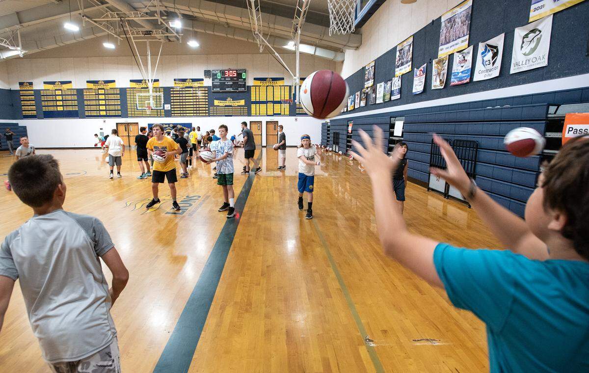 Kids work out in a passing drill during the Modesto Slam-N-Jam basketball camp at Big Valley Christian in Modesto, Calif., on Tuesday, July 5, 2022.