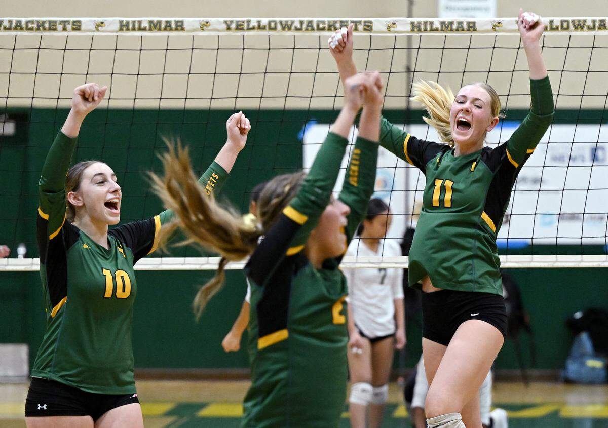 Hilmar’s players Finley Rosa (10), Reese Ahlem (11) and Sophie Stivers celebrate winning a point during the CIF Northern California Division IV volleyball championship with St. Patrick-St.-Vincent of Vallejo at Hilmar High School in Hilmar, Tuesday, Nov. 19, 2024. Hilmar won the match 3-0.