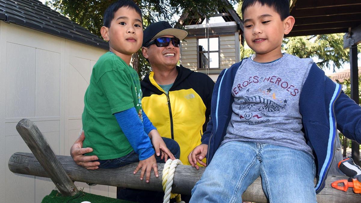 Rex Reyes (center) is pictured Wednesday afternoon April 10, 2019 with his 6-year-old twins Elijah (left) and Noah at their home in Ripon, Calif. Elijah was treated for leukemia when he was 4.