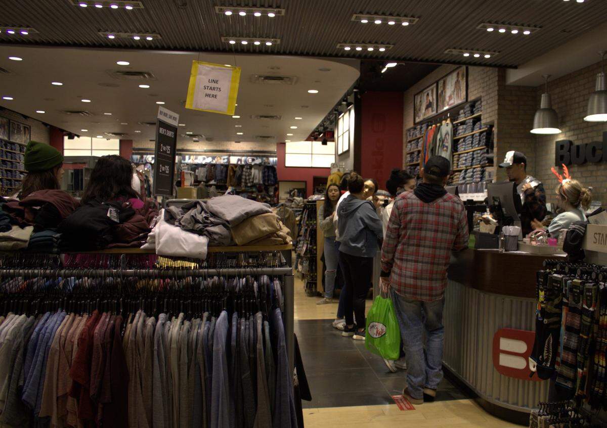 Holiday shoppers wait in line at Buckle in the Vintage Faire Mall on Dec. 5.