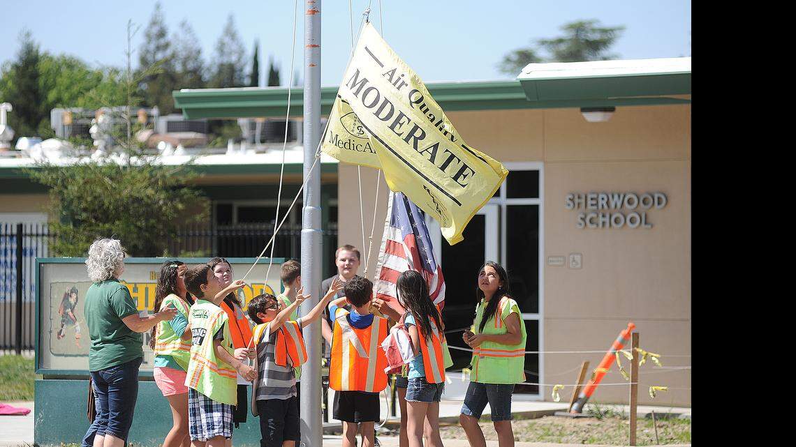 Elias Funez/efunez@modbee.com
Sherwood Elementary School 5th grade teacher Sarah Miller (left) watches over a group of 4th and 5th grade Traffic Control volunteers as they pull down the school's flags at the end of the school day Tuesday (04-23-13).
