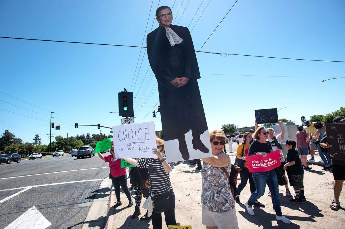 Jane Cloud holds a cardboard cutout of former Supreme Court Justice Ruth Bader Ginsburg as people gathered at McHenry Avenue to support abortion rights in Modesto, Calif., on Saturday, May 14, 2022.