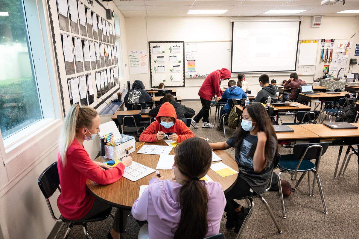 Fifth grade teacher Melinda Goodwin, left, helps students Camila Caracheo, Elianna Betancourt and Ignacio Valencia with multiplying decimals during class at Don Pedro Elementary School in Ceres, Calif., on Thursday, Nov. 4, 2021.