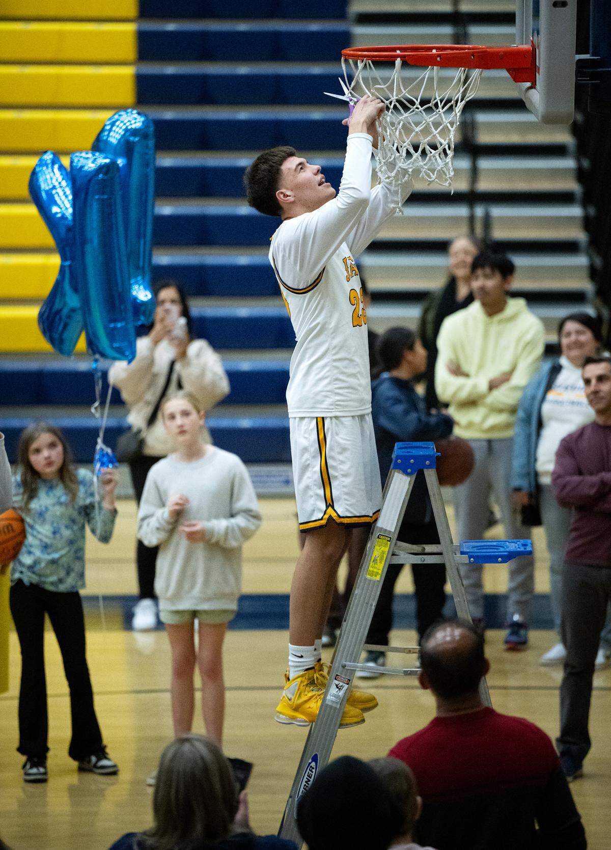 Gregori player Daniel Harter takes his turn at cutting the net after the Jaguars beat Pitman in the Central California Athletic League game at Gregori High School in Modesto, Wednesday, Feb. 12, 2025.