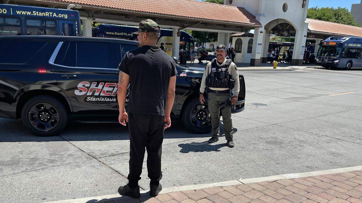 Stanislaus Sheriff’s Office Deputy Christian Izquierdo talks with a man at the Transit Center in Modesto, Wednesday, July 23, 2025.