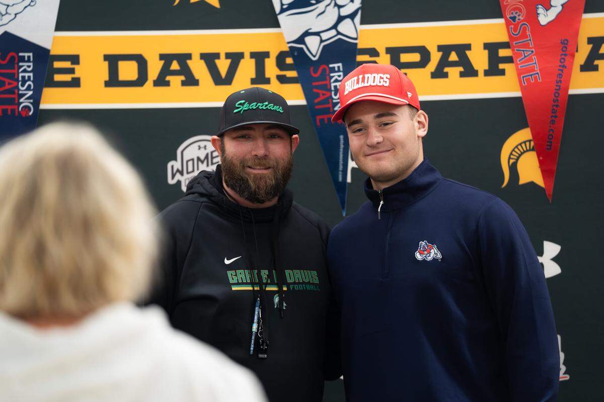Grace Davis High School football player Zane Gerbo takes a picture with head coach Trevor Mew after signing with Fresno State on National Signing Day in Modesto on Wednesday, Dec. 3, 2025.