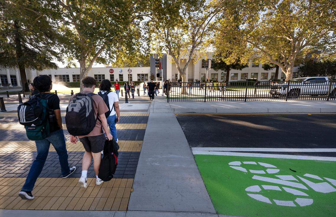 Students cross Paradise Road outside Modesto High School in Modesto, Calif., Tuesday, Aug. 20, 2024. The city recently reduced vehicle traffic to two lanes added bicycle lanes and improved the crosswalks around the school.