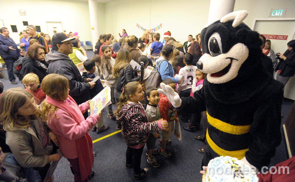Modesto Bee mascot Scoopy high-fives and greets children and families gathered at the Stanislaus County Library in downtown Modesto on Dec. 7, 2013 to celebrate his 70th birthday.
