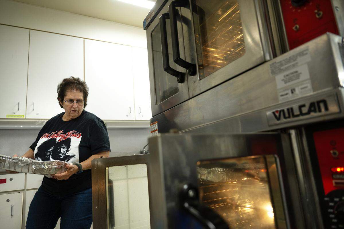 Joyce Gandelman puts lasagna in the oven as she and other volunteers prepare to deliver a holiday meal for first responders at Congregation Beth Shalom synagogue in Modesto, Tuesday, Dec. 24, 2024. Members of the congregation plan to deliver meals to area first responders Christmas Eve night.