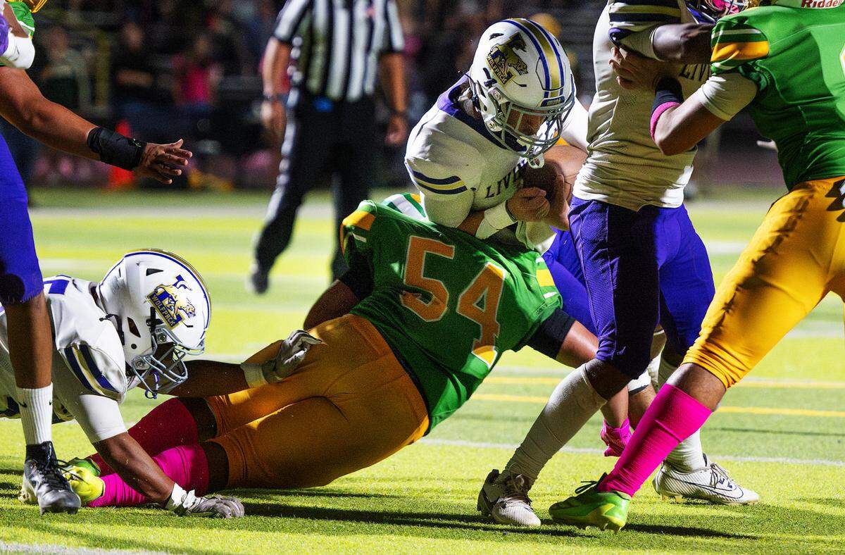 Davis’ Aron Olvera (54) stops quarterback Armani Miranda on fourth and goal to end a Livingston drive in the Western Athletic Conference game at Downey High School in Modesto, Calif., Thursday, Oct. 3, 2024.