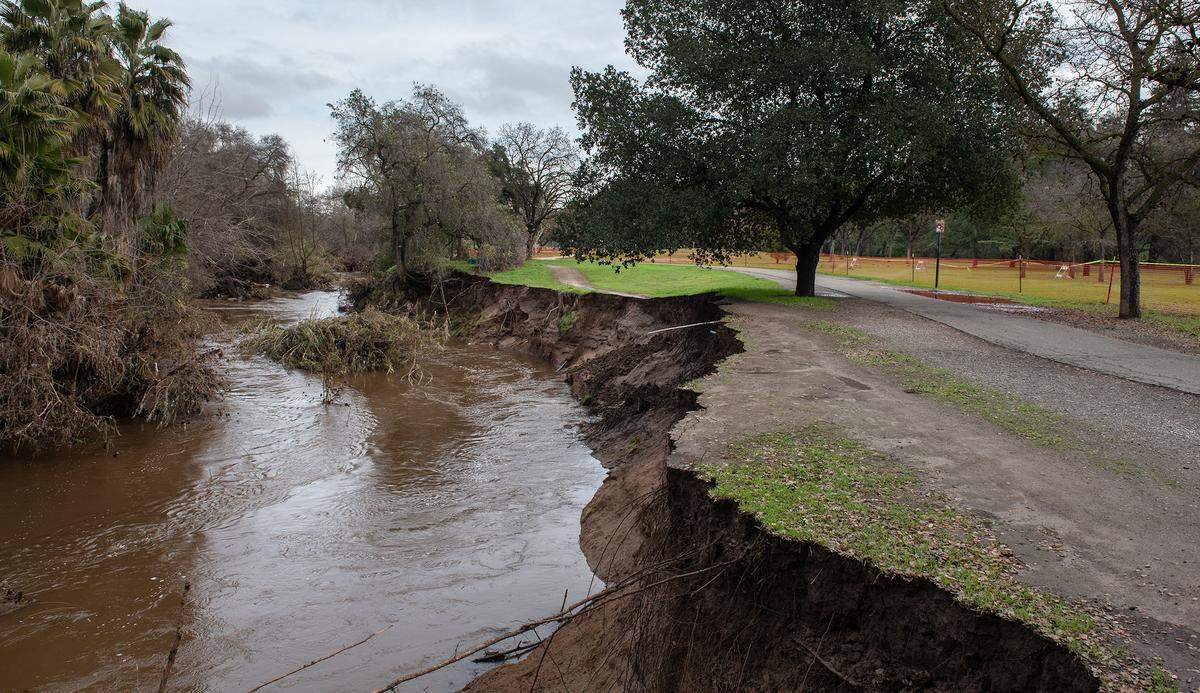 High water from the weekend storm damaged the bank along Dry Creek at East La Loma Park in Modesto, Calif., Tuesday, Jan. 3, 2023.