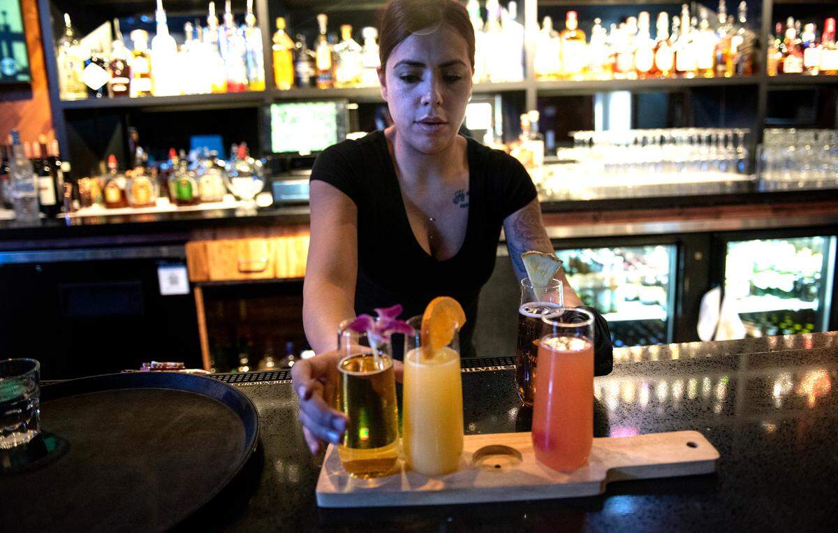 Sever Lupita Munoz prepares a flight of mimosa drinks at The Secret Garden restaurant in Modesto, Calif., on Thursday, May 19, 2022.
