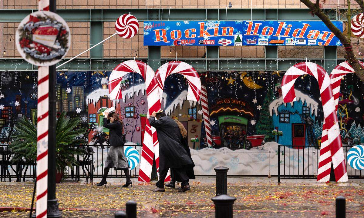 People walk in the rain past the Rockin’ Holiday display in downtown Modesto, Calif., Thursday, Dec. 1, 2022. Will it rain in Modesto on Christmas Day, Dec. 25, 2024?
