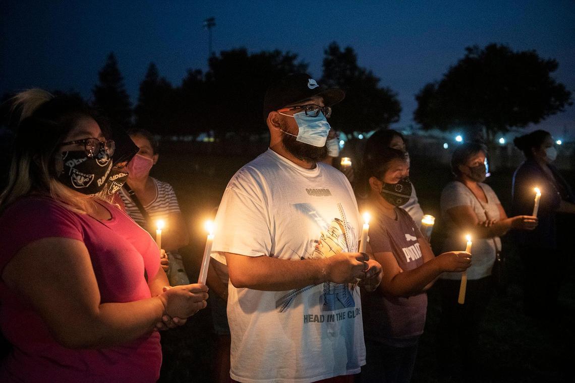 Foster Farms employee Kevin Vera, 28, of Livingston, center, attends a community candlelight vigil with family members at the Max Foster Sports Complex in Livingston, Calif., on Thursday, Sept. 3, 2020. The vigil was held to honor the eight lives lost and hundreds of families impacted by a COVID-19 outbreak at Foster Farms’ Livingston plant.