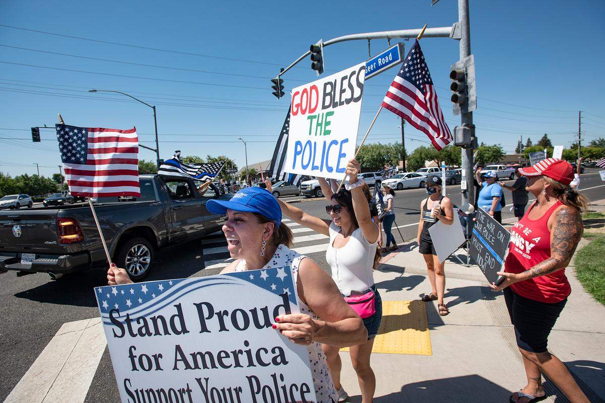 Law enforcement supporters call out to motorists on Monte Vista Avenue during a Back the Badge rally in Turlock, Calif., on Saturday, June 27, 2020.