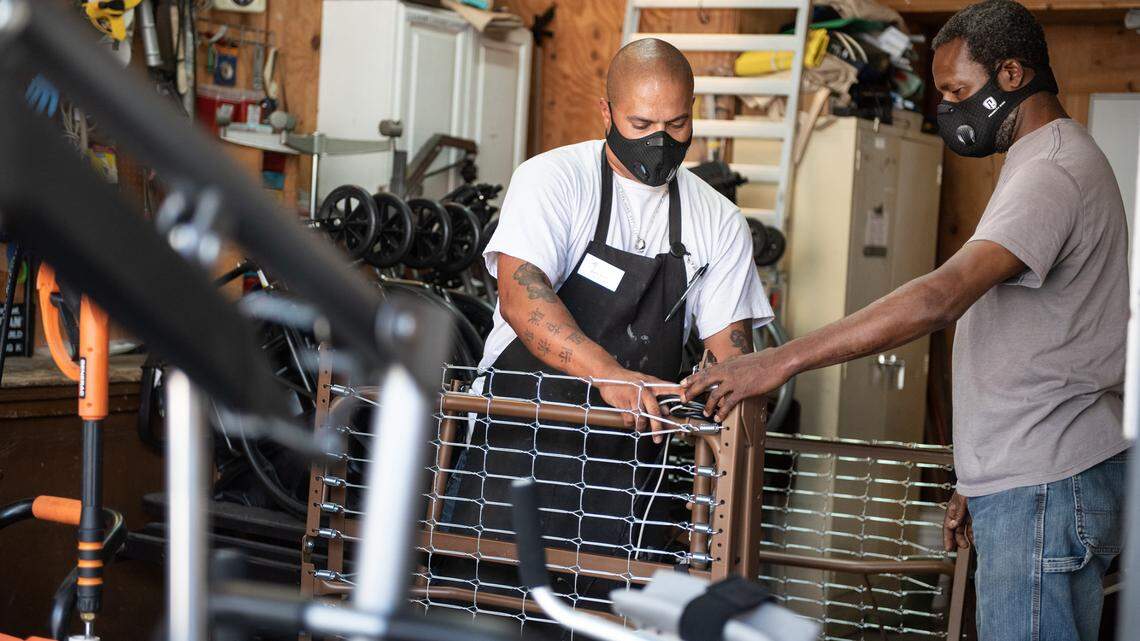 Durable medical Equipment specialist Zach Smith, left, and assistant Lawrence Crockett, right, inspect a medical bed at The Society for Disabilities in Modesto, Calif., on Thursday, July 23, 2020. The society is among the Stanislaus County nonprofits participating in the NextGen on Board fellowship program.