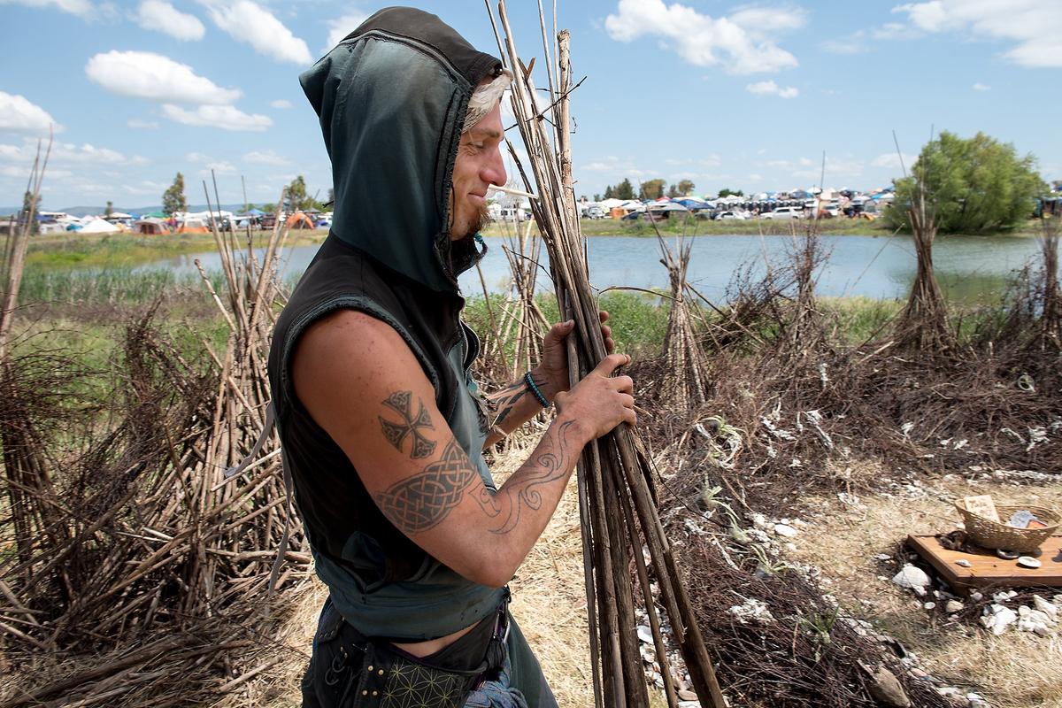 Shaman Kratos salvages reeds from the marsh to create a "healing space" during the Serenity Gathering at Woodward Reservoir in Oakdale, Calif., Saturday, April 28, 2018.
