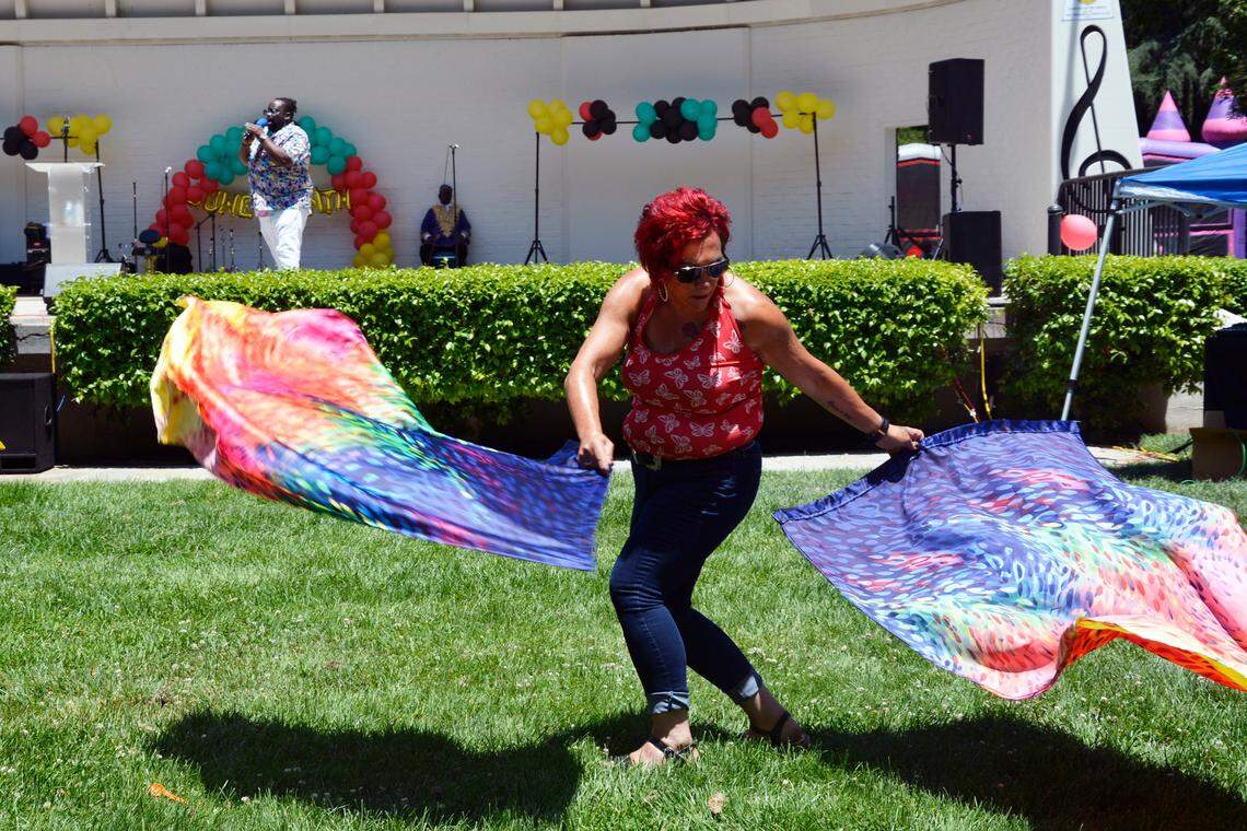 Juvenalia Gouveia of Turlock twirls flags during a performance at the Modesto Juneteenth celebration in Graceada Park on Saturday, June 17, 2023.