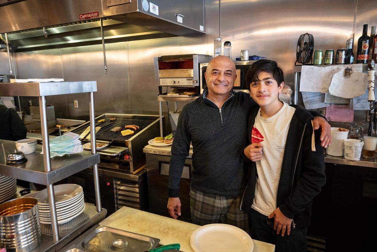 Owner Hanibal Yadegar and his son Atanous, 14, at Barkin’ Dog Grill in Modesto, Calif., on Thursday, Dec. 16, 2021.