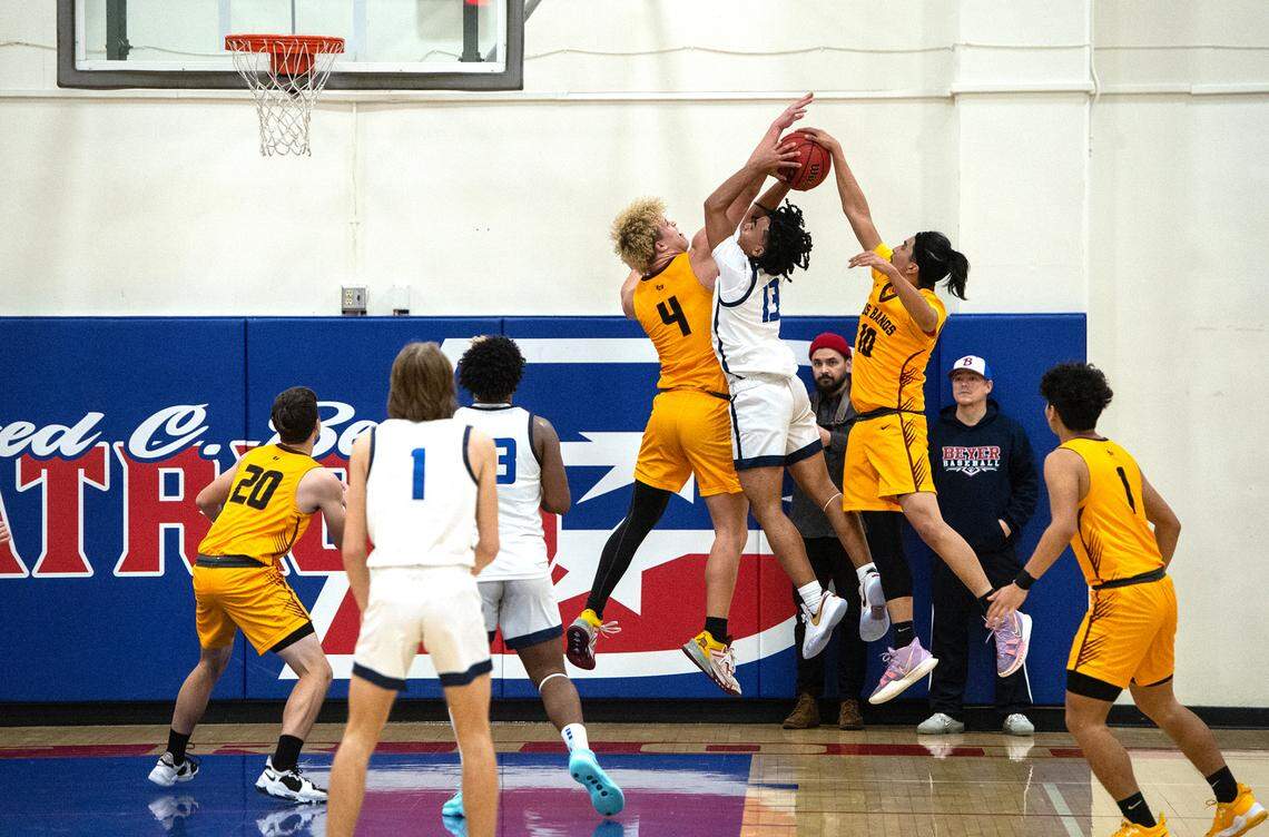 Los Banos players Ayden Barcellos (4) and Angel Resendiz (10) stop Beyer’s Noah Ramilo on a drive to the basket during the Western Athletic Conference game at Beyer High School in Modesto, Calif., Wednesday, Jan. 4, 2023.
