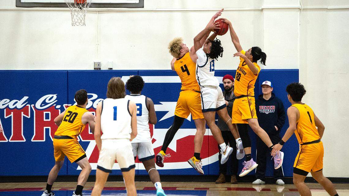 Los Banos players Ayden Barcellos (4) and Angel Resendiz (10) stop Beyer’s Noah Ramilo on a drive to the basket during the Western Athletic Conference game at Beyer High School in Modesto, Calif., Wednesday, Jan. 4, 2023.
