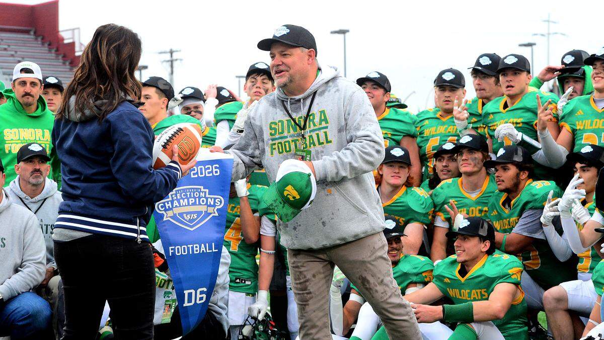 Sonora Wildcats coach Kirk Clifton accepts the CIF Sac-Joaquin Section Division VI banner after defeating Ripon Christian 56-18 at Hughes Stadium on Saturday. The Wildcats will host Woodcreek of Roseville on Saturday. 