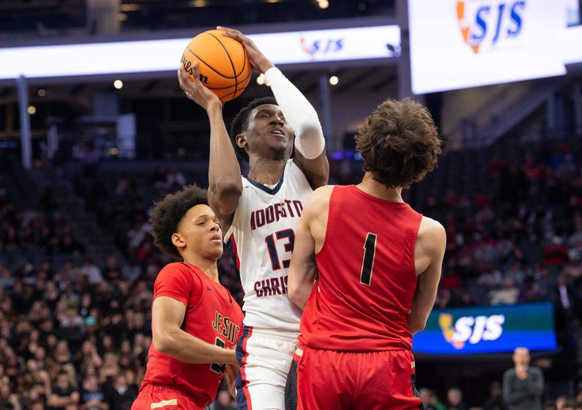 Modesto Christian’s Prince Oseya attacks the basket as Jesuit’s Reid Jones defends during the Sac-Joaquin Section Division I championship game at Golden 1 Center in Sacramento, Calif., Saturday, Feb. 25, 2023.