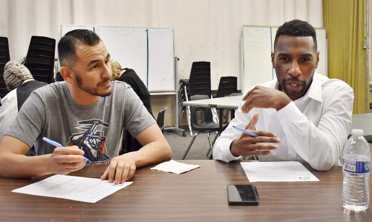 Jose Cardenas, a Davis High parent, and Reggie Rucker, a director with Stanislaus Partners in Education, talk with table-mates at a community focus group meeting Monday evening, Oct. 15, 2018 at Downey High School.