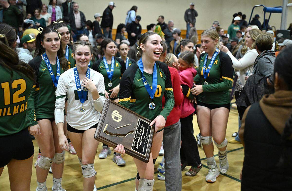 Hilmar’s Finley Rosa, middle, holds the championship trophy after her team won the CIF Northern California Division IV volleyball championship over St. Patrick-St. Vincent of Vallejo at Hilmar High School in Hilmar, Tuesday, Nov. 19, 2024.