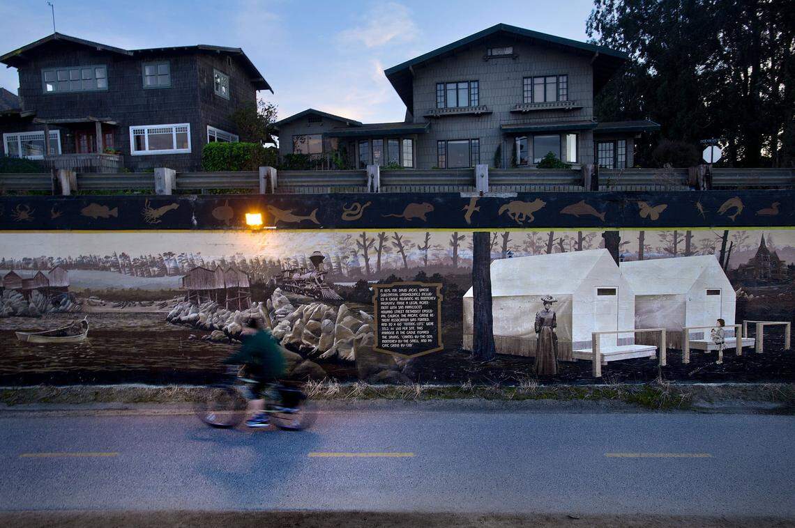 A bicyclist pedals past an extensive mural last month near Lovers Point in Pacific Grove, just west of Monterey.