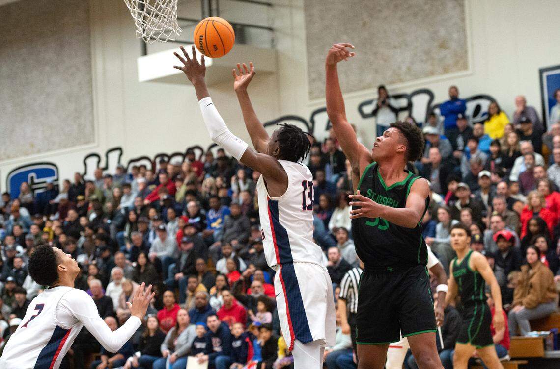 Modesto Christian’s Prince Oseya grabs a rebound from St. Joseph’s Caedin Hamilton during the NorCal Open Division championship game at Modesto Junior College in Modesto, Calif., Tuesday, March 7, 2023. St. Joseph won the game 72-58.