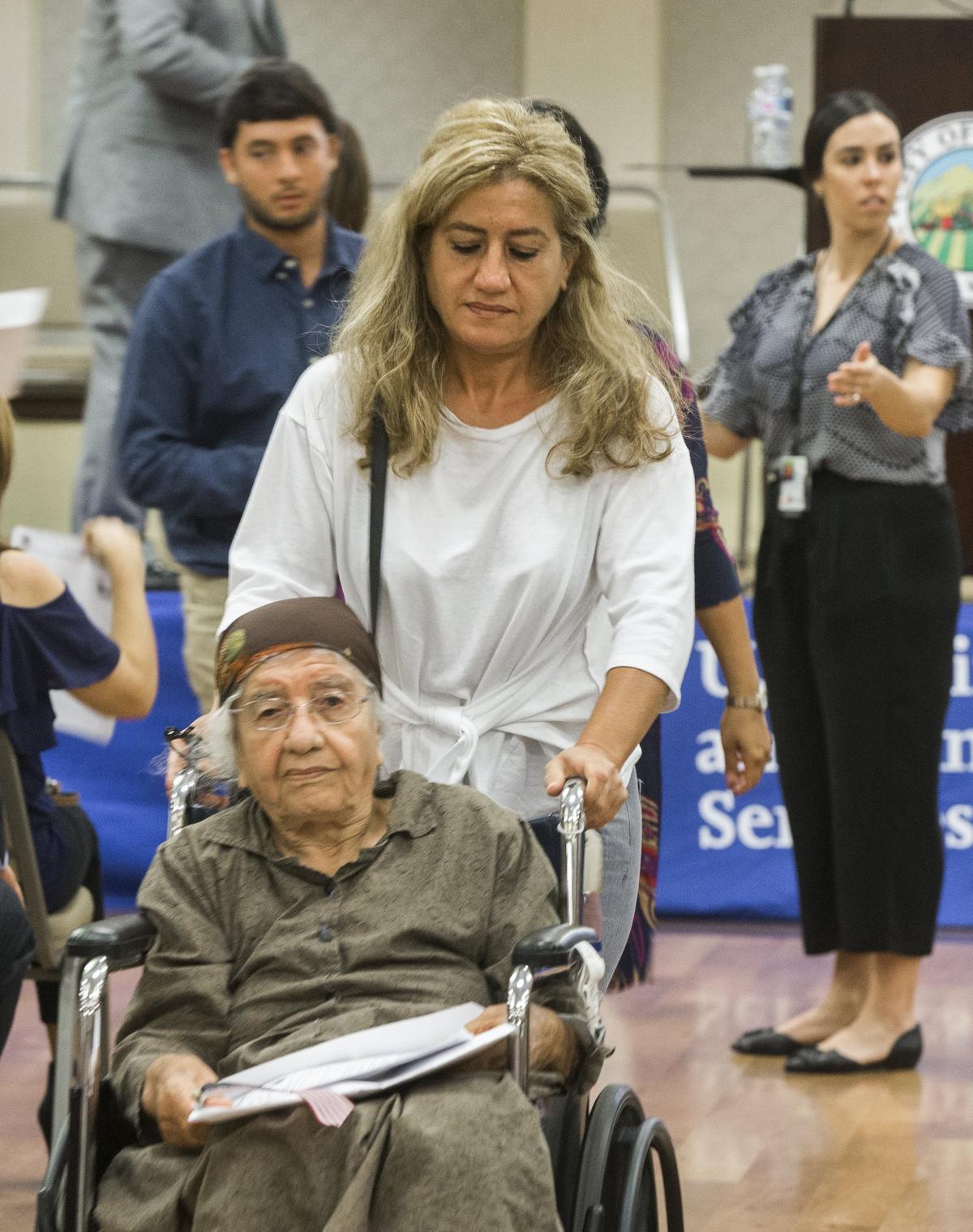 Ileshwa Khoshaba, sitting, and her niece Alma Bankho walk out after finishing the final steps to becoming a US citizen during the Naturalization Ceremony at the Ceres Community Center Monday July 31, 2018.