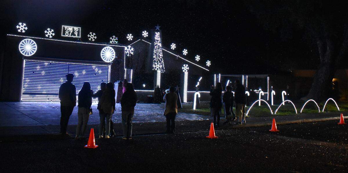 An audience takes in the light show and snowfall Friday night, Dec. 10, 2021, at Norman Esakhnai’s home at 731 E. Tuolumne Road in Turlock.