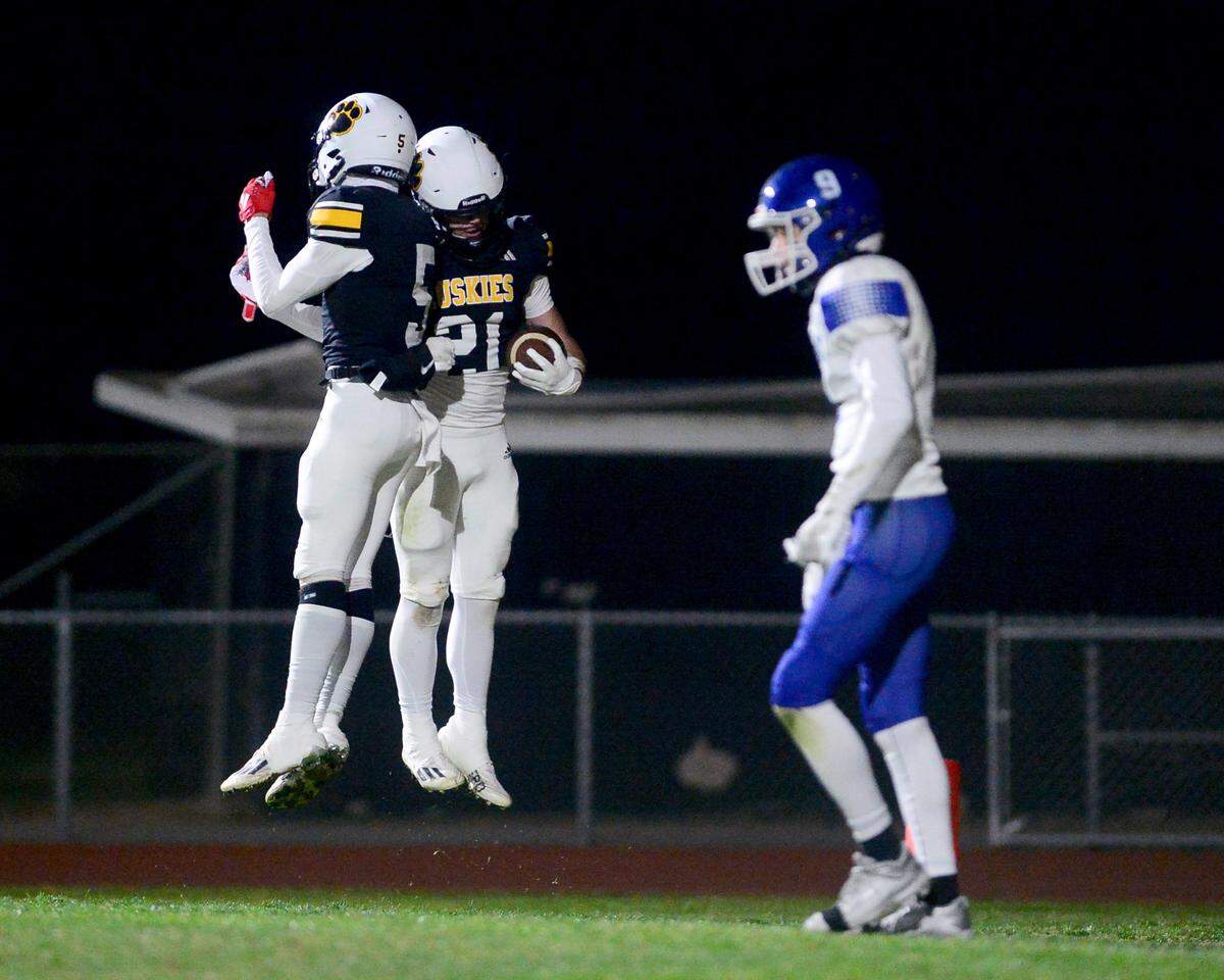 Hughson running back Eli Wilbanks (21) celebrates a touchdown with teammate Lincoln Sousa (5) during a 2024 CIF Sac-Joaquin Section Division V Playoff game between Hughson High School and El Dorado High School at Hughson High School in Hughson California on November 15, 2024. Hughson won the game 28-6.
