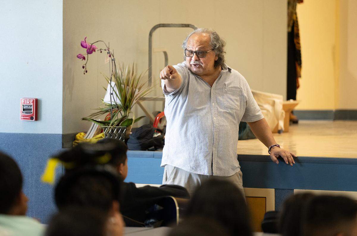 Stanislaus State University literature professor Manuel Murrieta has fun with some of the students during an arts after-school program at Bret Harte Elementary School in Modesto, Calif., Wednesday, May 22, 2024.