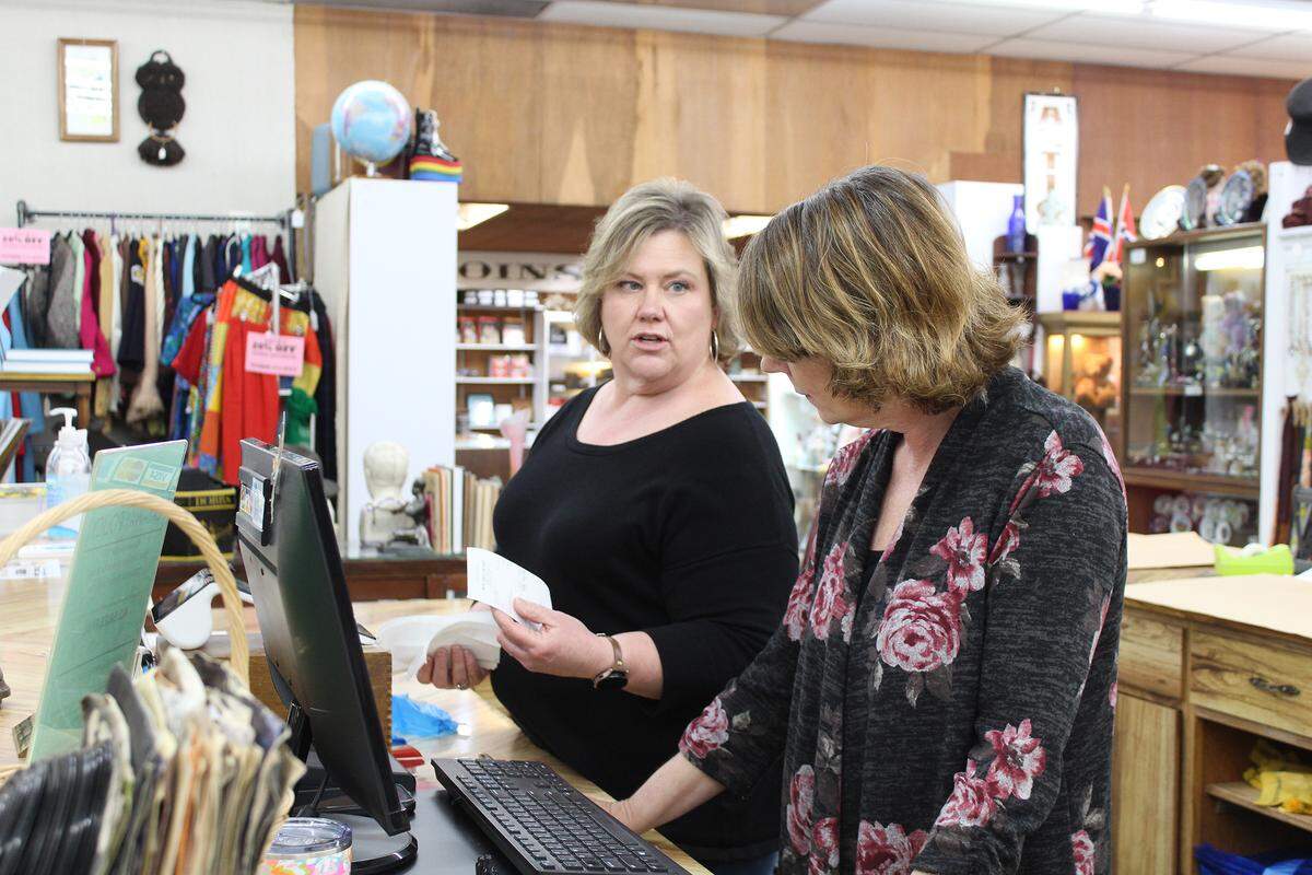 Jennifer Jensen, left, shows order receipts to Lori Smith, right, at Main Street Antiques in Turlock, Calif., on Tuesday, April 19, 2022. Smith, who co-owns the store with Jensen, said downtown Turlock businesses have been resilient during the COVID-19 pandemic.