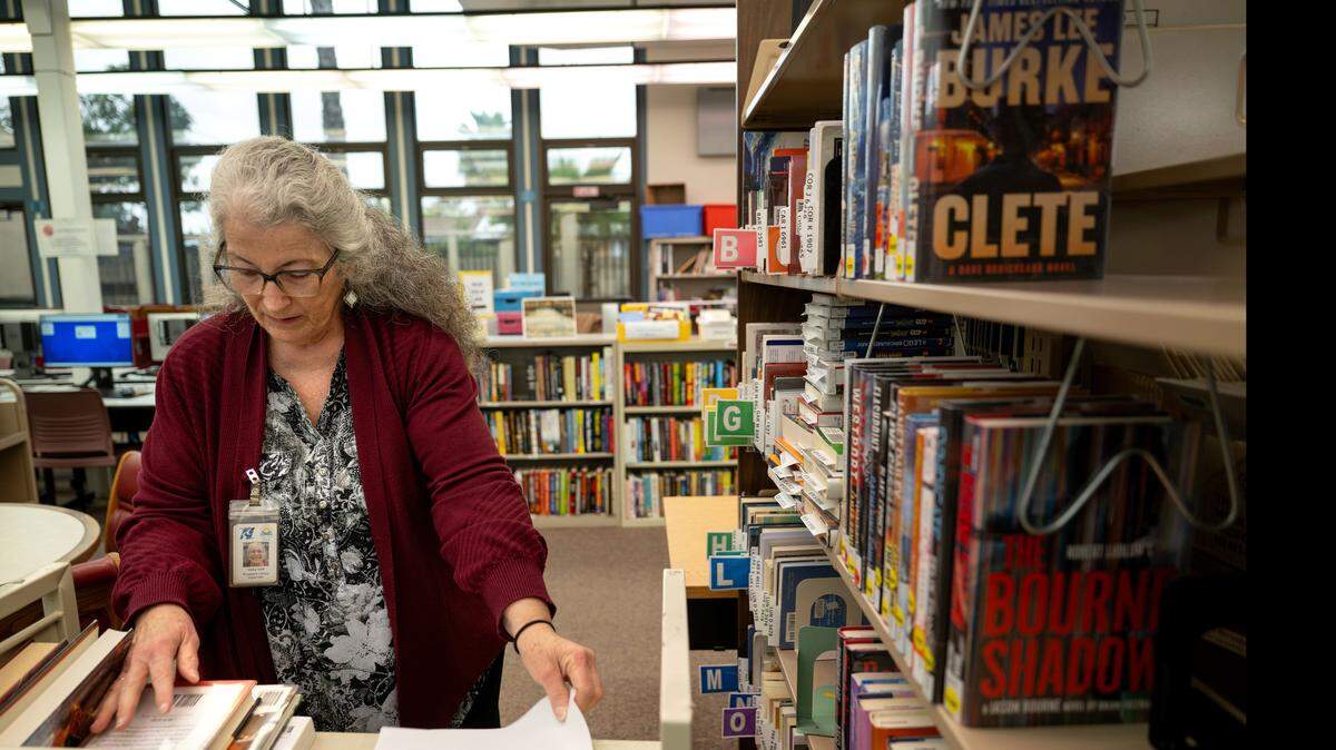 Library supervisor Vicky Holt sorts books on customer hold at the Stanislaus County Library branch in Riverbank, Friday, April 1, 2025.