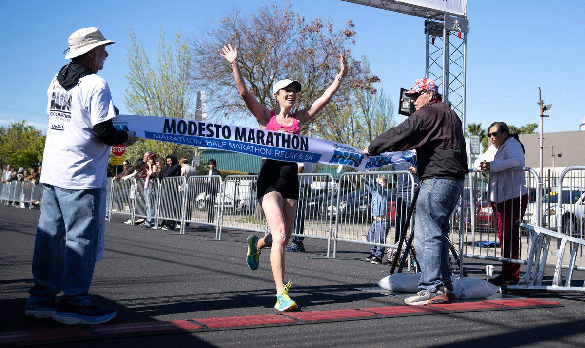 Women’s marathon winner Eve Schaeffer crosses the finish line with a time of 3:17:44 in the Modesto Marathon in Modesto, Sunday, March, 23, 2025.