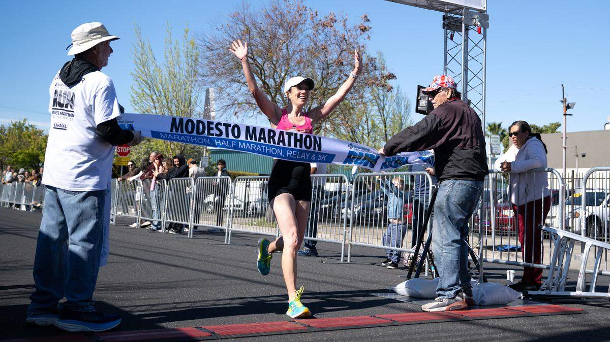 Women’s marathon winner Eve Schaeffer crosses the finish line with a time of 3:17:44 in the Modesto Marathon in Modesto, Sunday, March, 23, 2025. 