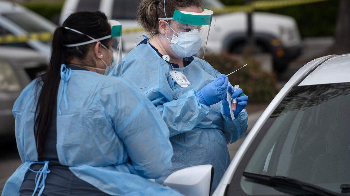 Nurse practitioner Danielle Groce administers a COVID-19 test at a Golden Valley Health Center test station in Ceres, Calif., on Wednesday, March 25, 2020. Medical assistant Maria Aragon, left, helps with translation. GVHC have two drive-thru viral testing sites, one in Ceres and one in Merced, but these are available only for GVHC clients from 9 a.m. to 3 p.m. with a referral from their provider.