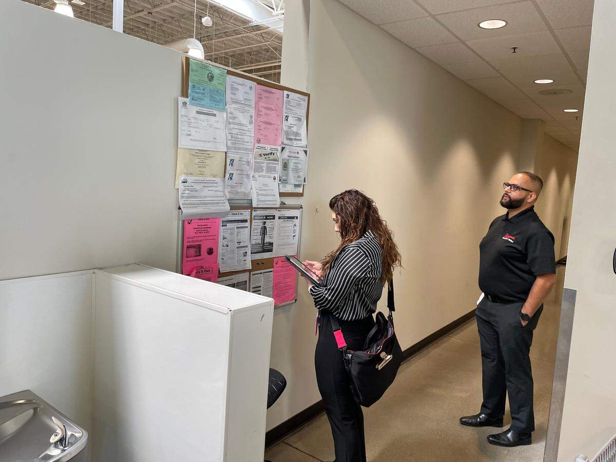 Registered Environmental Health Specialist Alondra Estrada checks permits and health postings while Senior Food Safety Manager, Parminder Dhillon looks on during a routine health inspection inside Save Mart on Sept. 5, 2024.