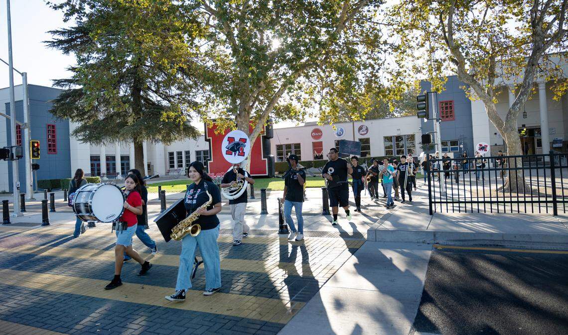 Members of the school band cross Paradise Road outside Modesto High School in Modesto, Calif., Tuesday Oct. 8, 2024. The band performed during a ribbon-cutting ceremony for the redesigned crosswalk and section of road in front of the school.