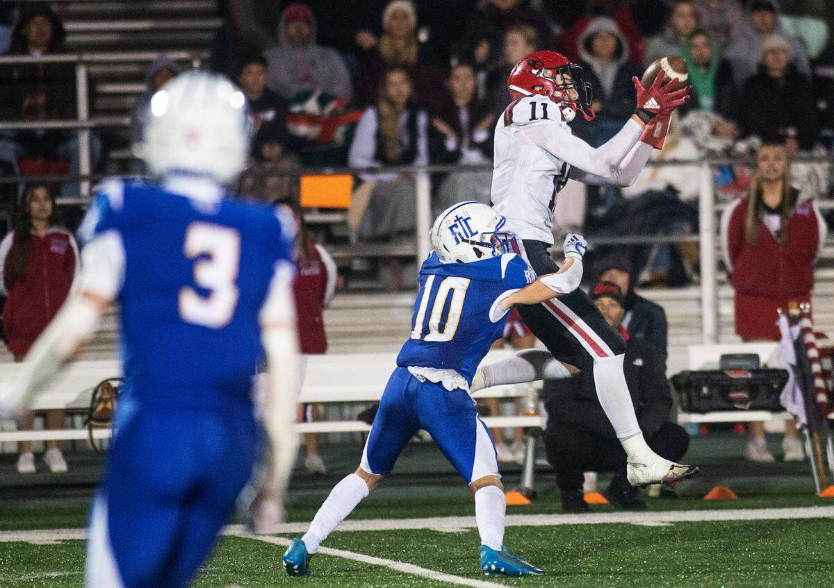 Woodland Christian’s Carter Lang makes a catch as Ripon Christian’s Brady Grondz defends during the Sac-Joaquin Section Division VII championship game at St. Mary’s High School in Stockton, Calif., Friday, Nov. 25, 2022.