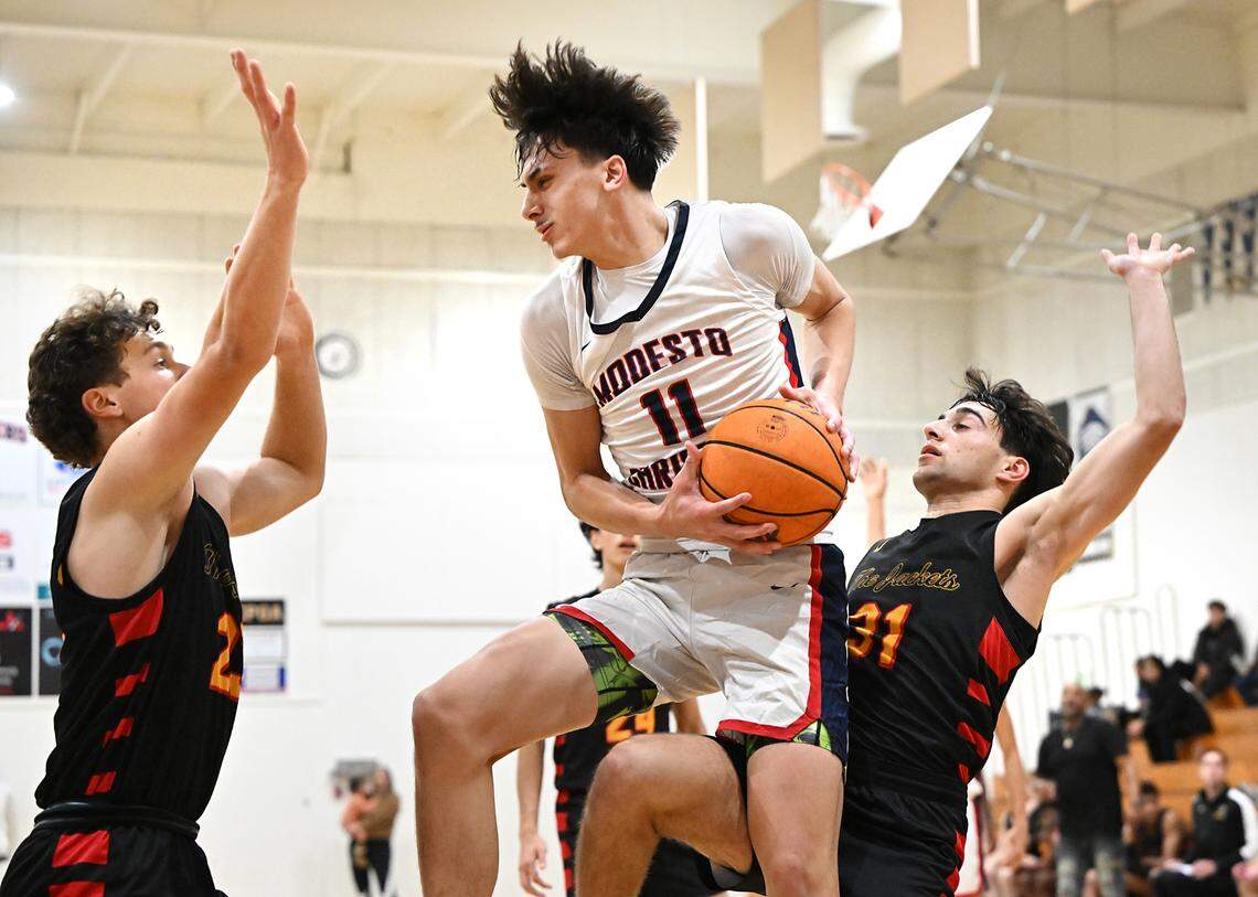 Modesto Christian’s Judah Flores pulls down a rebound between Berkeley defenders Will Polishuk, left, and Ollie Miller during the game at Modesto Christian High School in Salida, Calif., Saturday, Dec. 16, 2023.