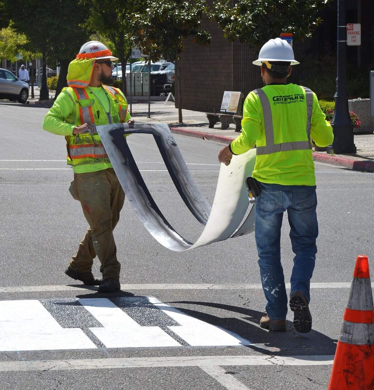 Workers lift the template after spraying one of the black keys at 11th and I streets on Tuesday, April 25, 2016.